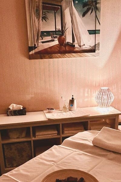 Behandlungsraum mit Regal, Handtüchern und Wandbild